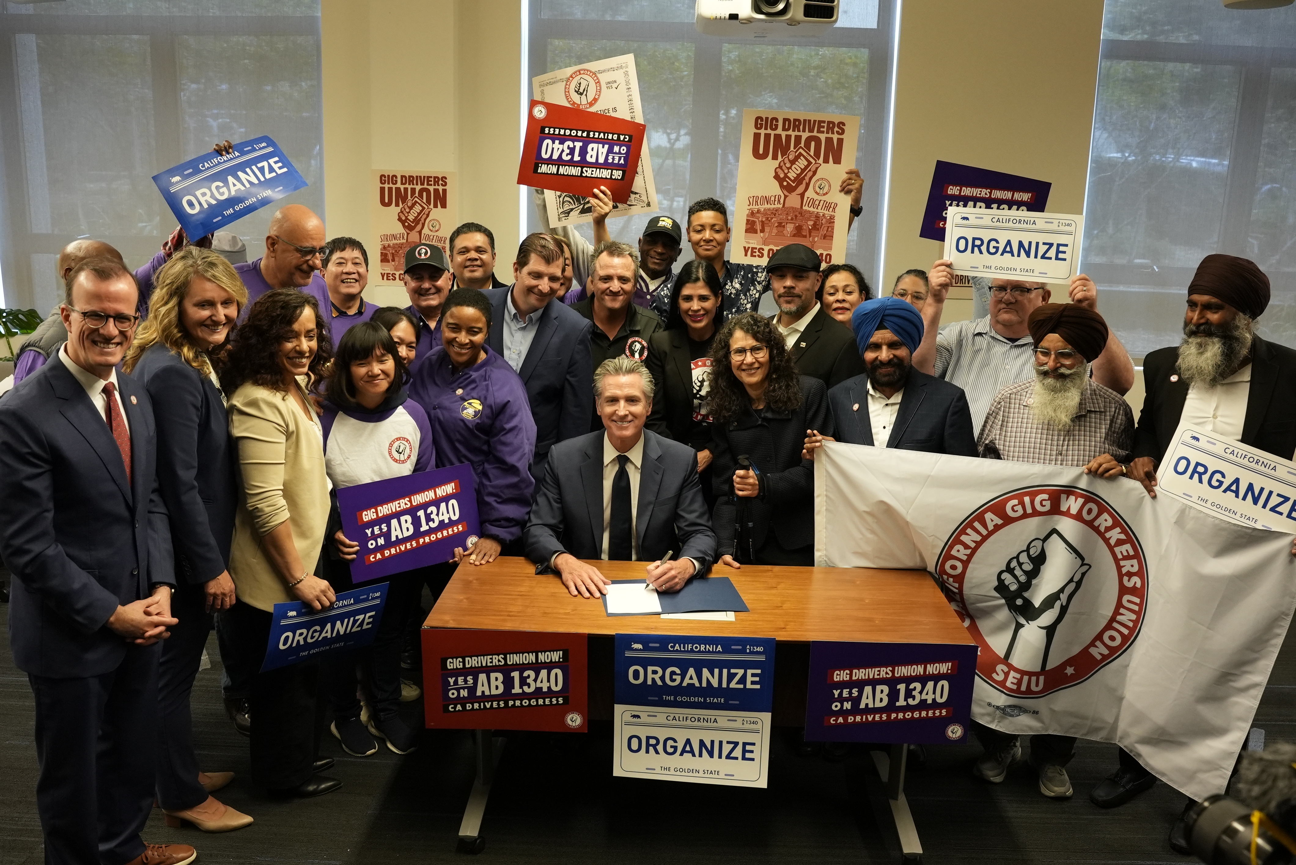Asm. Berman, Asm. Wicks, and California rideshare drivers with Gov. Gavin Newsom as he signs AB 1340
